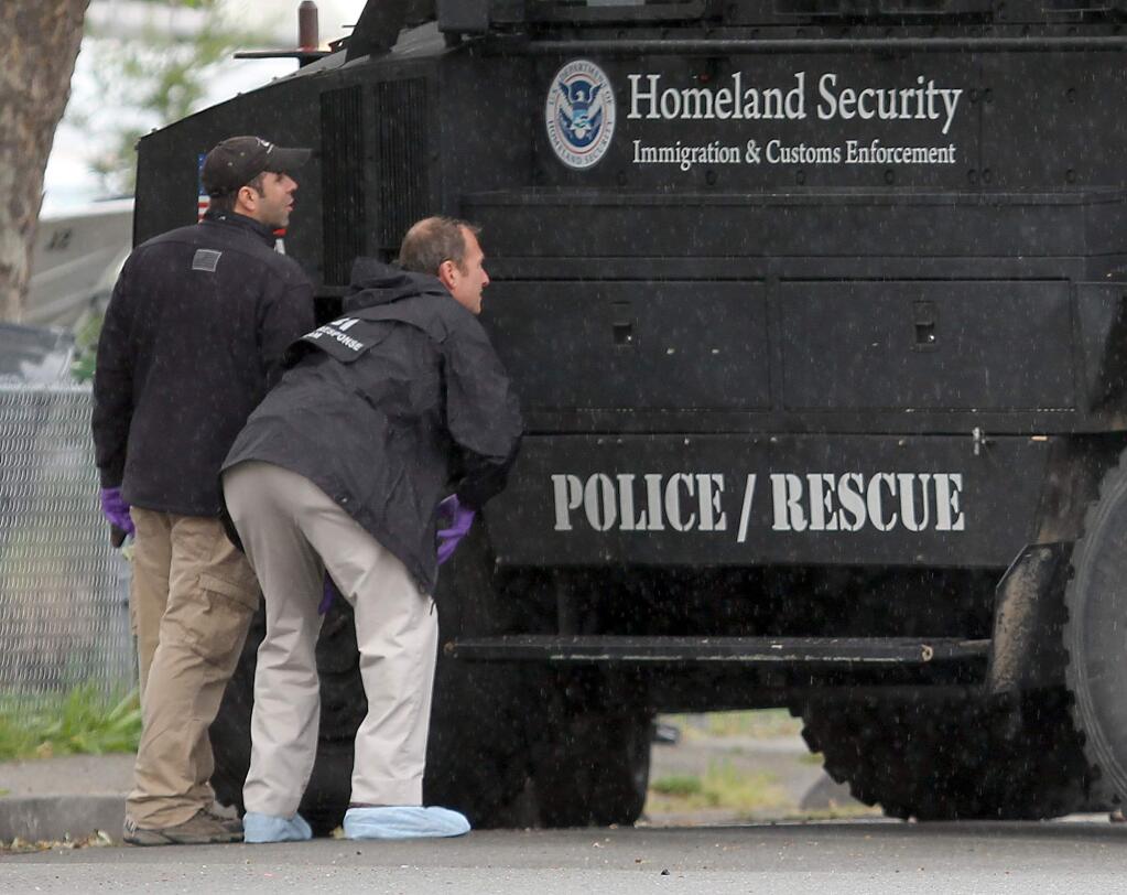 FBI emergency response technicians looks for bullet fragments on a Homeland Security vehicle used in a raid at a Petaluma home by federal agents in 2012. (KENT PORTER/ PD FILE)