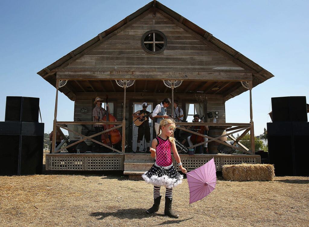 The 6th annual Rivertown Revival is Saturday, July 18, 2015. In this archive photo, Madeline Maloney, 5, waits for the music to start at the Front Porch stage at Saturday's Rivertown Rival in Petaluma. (Conner Jay/Press Democrat 2013)
