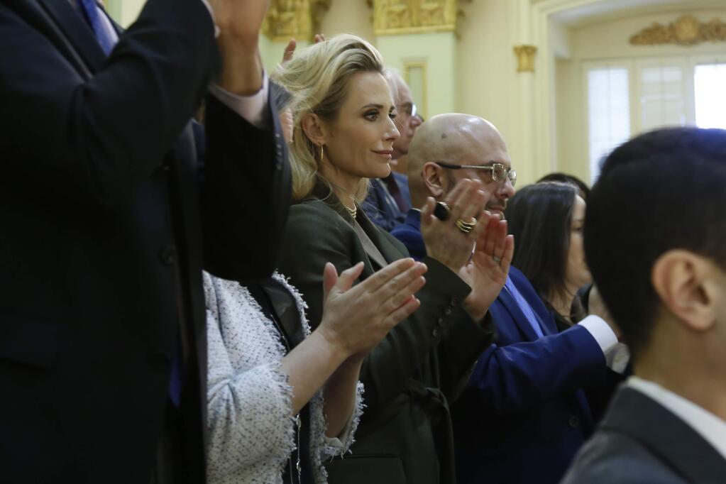 California First Partner Jennifer Siebel Newsom, center, joins with others to give her husband, Gov. Gavin Newsom, a standing ovation as he delivers his State of the State address to a joint session of the legislature at the Capitol in Sacramento, Calif., Wednesday, Feb. 19, 2020. (AP Photo/Rich Pedroncelli, Pool)