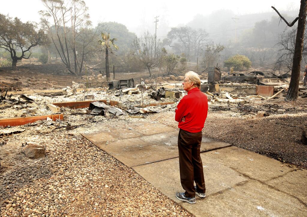 Mike Rippey looks over the burned out remains of his parents home at the Silverado Resort, Tuesday, Oct. 10, 2017, in Napa, Calif. Charles Rippey, 100 and his wife Sara, 98, died when wind whipped flames swept through the area Sunday night. (AP Photo/Rich Pedroncelli)