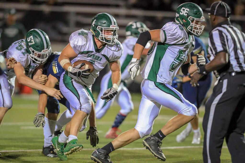 Tyler Winslow (4) with the ball on one of his 22 carries in the Sonoma Valley vs. Napa High football game on Sept. 14, behind Gavin Lehane (56). Winslow also anchored the Dragon defense in their first-ever Vine Valley Association League game, which ended in a 28-16 Dragon victory. (Don Lex/LuckyDuckImages.com)