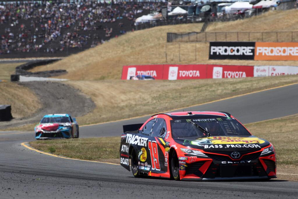 Martin Truex Jr. (19) of Bass Pro Shops Toyota, takes a lead over Kyle Busch (18), background, on his way to victory, during the Toyota/Save Mart 350 Monster Energy NASCAR Cup Series Race, at Sonoma Raceway, on Sunday, June 23, 2019. (Photo by Darryl Bush / For The Press Democrat)