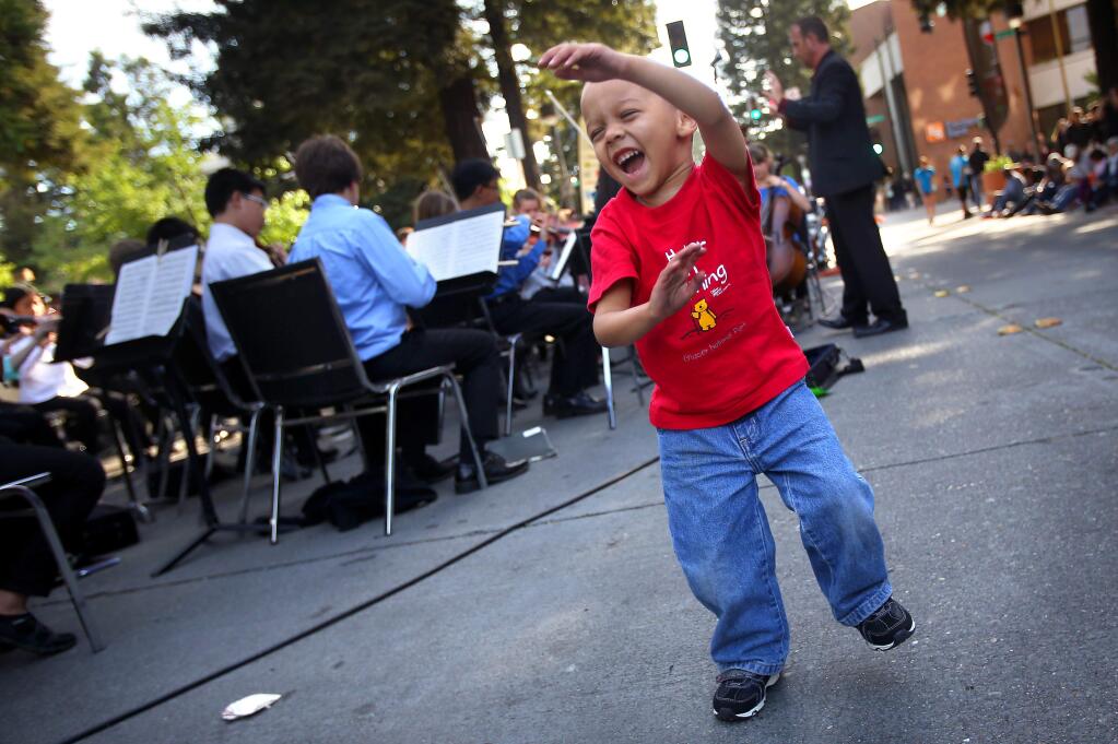 George Barnas, 2, dances to music performed by the Santa Rosa Youth Symphony Repertory Orchestra during the Wednesday Night Market, in downtown Santa Rosa on Wednesday, May 7, 2014. (Christopher Chung/ The Press Democrat)