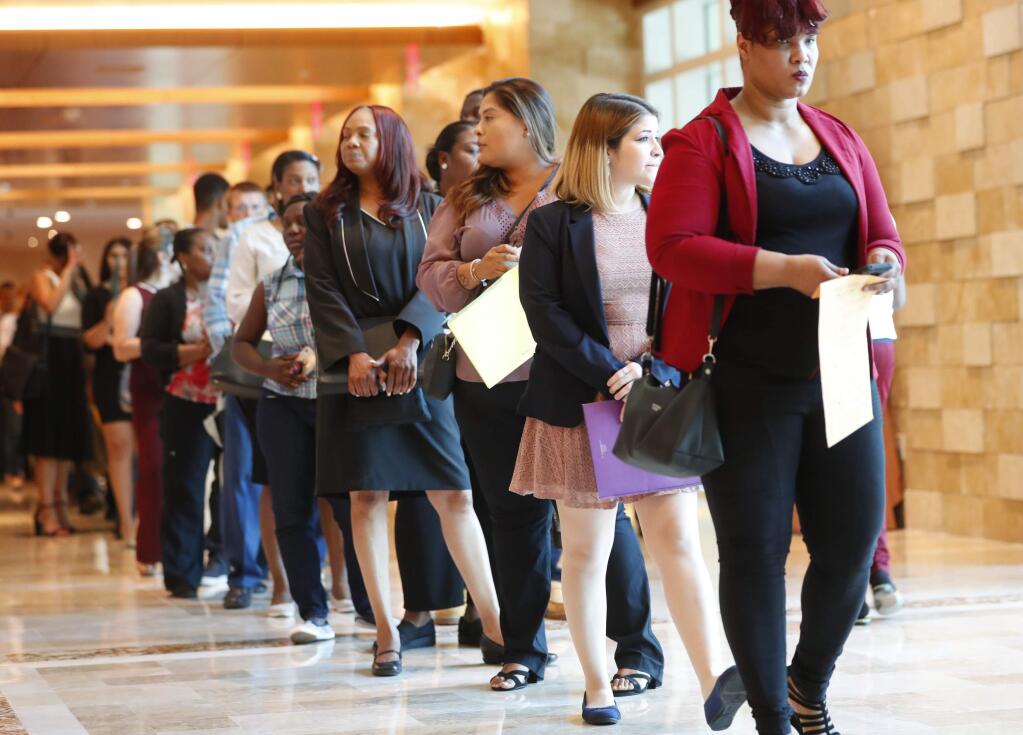 In this Tuesday, June 4, 2019 photo, job applicants line up at the Seminole Hard Rock Hotel & Casino Hollywood during a job fair in Hollywood, Fla. On Friday, July 5, the U.S. government issues the June jobs report. (AP Photo/Wilfredo Lee)