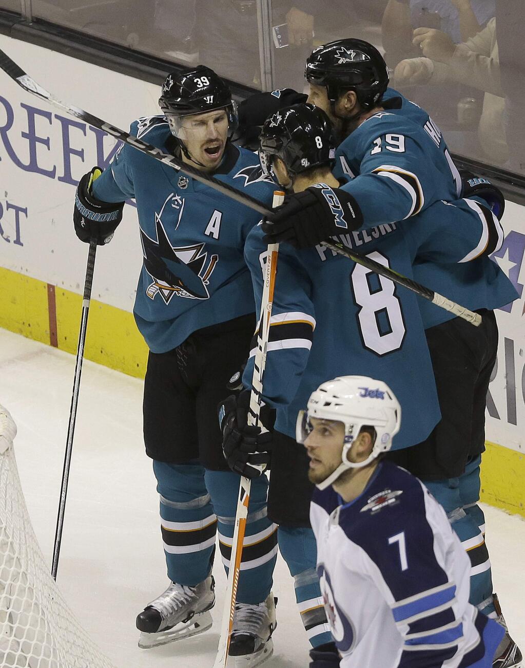 San Jose Sharks center Logan Couture, left, is congratulated by center Joe Pavelski (8) and center Joe Thornton (19) after scoring a goal against the Winnipeg Jets during the first period in San Jose, Saturday, Nov. 25, 2017. (AP Photo/Jeff Chiu)