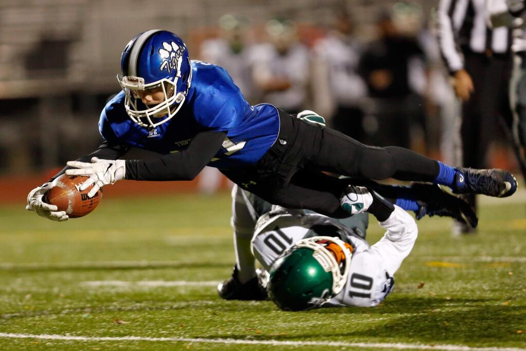 Analy's Ross Simmons (17) fights through a tackle by El Cerrito's Aaron Taylor (10) and reaches to score Analy's first touchdown of the NCS Division 3 quarterfinal football game between Analy and El Cerrito high schools, in Santa Rosa, California on Friday, November 20, 2015. (Alvin Jornada / The Press Democrat)