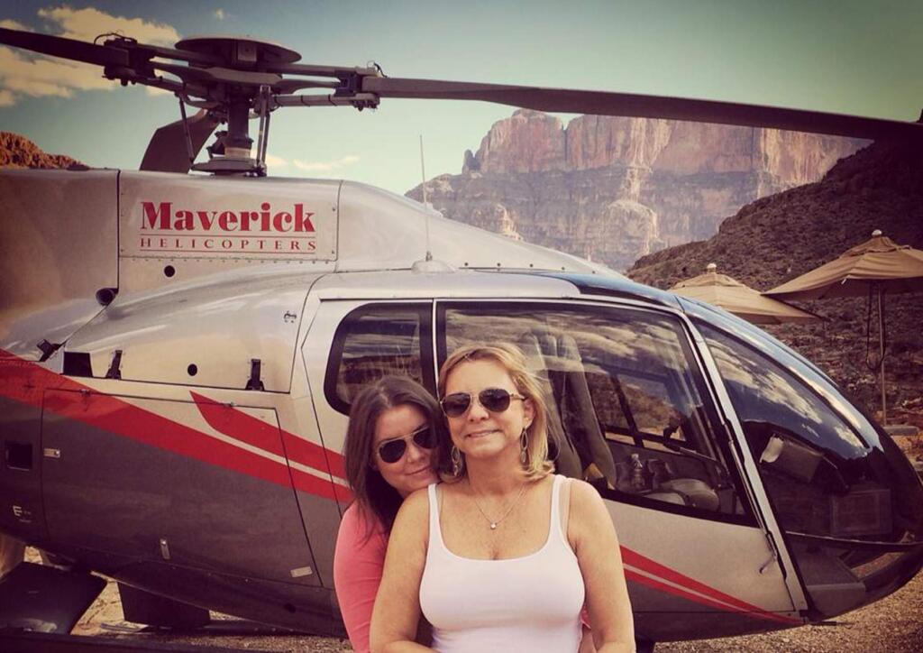 In this Oct. 21, 2014 photo provided by TheBrittanyFund.org, Brittany Maynard, left, hugs her mother Debbie Ziegler next to a helicopter at the Grand Canyon National Park in Arizona. The 29-year-old terminally ill woman has fulfilled a wish on her bucket list: visiting the Grand Canyon. Maynard, who has advanced brain cancer, has said she plans use Oregon's death-with-dignity law to end her own life Saturday, Nov. 1, 2014 though she could still change her mind. Maynard and her husband moved to Oregon from Northern California because Oregon allows terminally ill patients to end their lives with lethal medications prescribed by a doctor. (AP Photo/TheBrittanyFund.org)