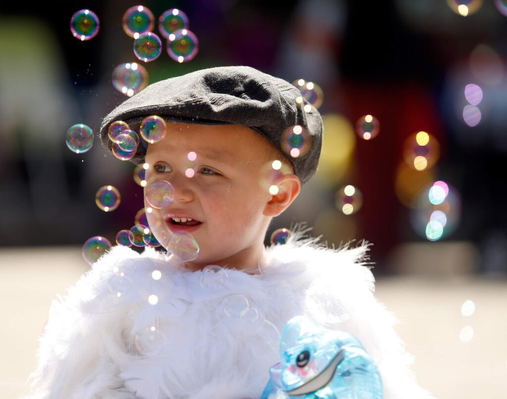Israel Edwards, 2, plays with his bubble maker after the Cutest Little Chick Contest at the Butter & Egg Days Parade in Petaluma, California, on Saturday, April 23, 2016. (Alvin Jornada / The Press Democrat)