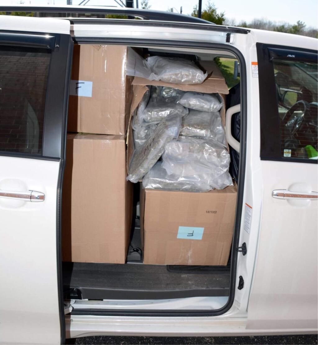 This photo released by Rhode Island State Police, Wednesday, April 20, 2016, shows a minivan containing boxes and packets of marijuana. Police say a Philadelphia man was found with 317 pounds of marijuana during a traffic stop in Warwick, R. I. Police said Wednesday that Jian Zhi Li, 44, is charged with possession of marijuana with intent to deliver and related crimes. (AP Photo/Rhode Island State Police)