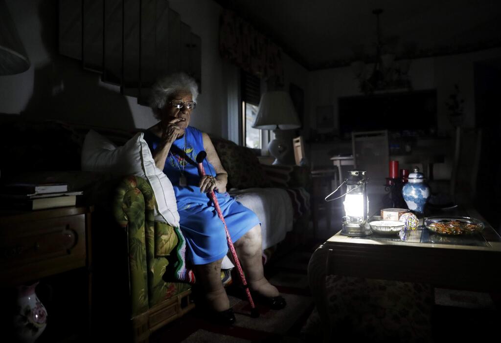 Mary Della Ratta, 94, sits by a battery powered lantern in her home three days after Hurricane Irma knocked out power in Naples, Fla., Wednesday, Sept. 13, 2017. 'I don't know what to do. How am I going to last here?' said Della Ratta. The number of people without electricity in the steamy late-summer heat was down to 6.8 million. Utility officials warned it could take over a week for power to be fully restored. (AP Photo/David Goldman)