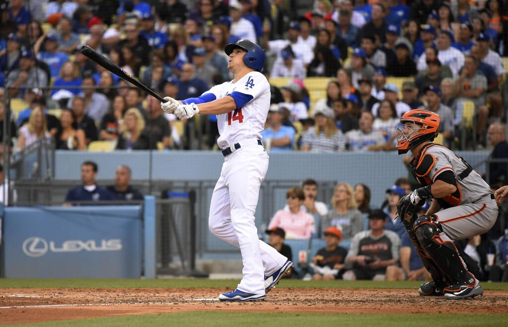 Los Angeles Dodgers' Enrique Hernandez, left, hits a two-run home run as San Francisco Giants catcher Buster Posey, left, watches during the fifth inning of a baseball game Saturday, June 16, 2018, in Los Angeles. (AP Photo/Mark J. Terrill)