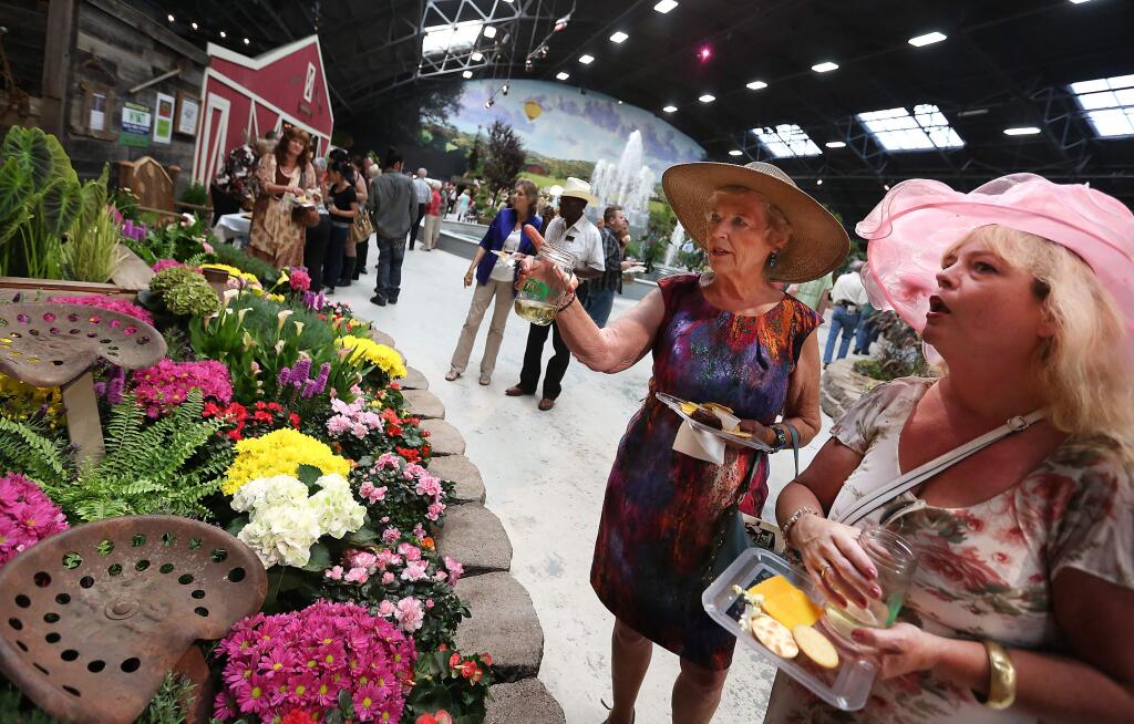 Donna Christiansen, left, and Julie Hincher, right, check out one of the flower displays during the Preview Party for the Sonoma County Fair Hall of Flowers, Thursday, July 23, 2015. (Crista Jeremiason / The Press Democrat)