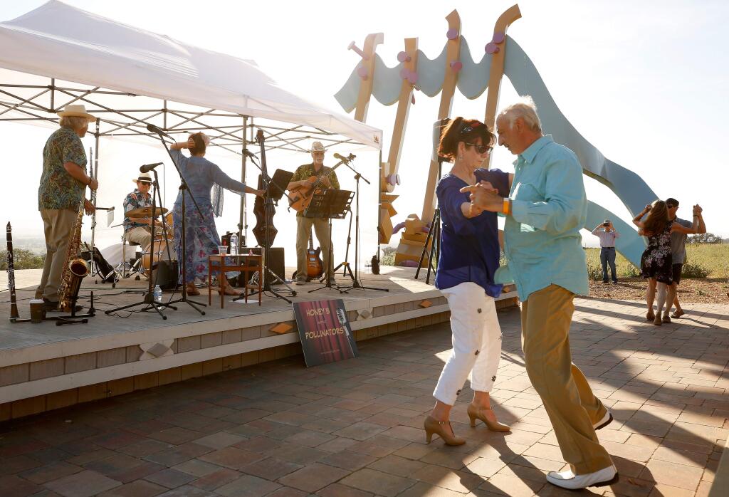 Fire survivors Adrian Litman, right, and his wife, Cornelia van Aken, dance together while Honey B and the Pollinators perform on stage during the summertime Wine and Sunsets event at Paradise Ridge Winery in Santa Rosa, California, on Wednesday, July 17, 2019. (Alvin Jornada / The Press Democrat)