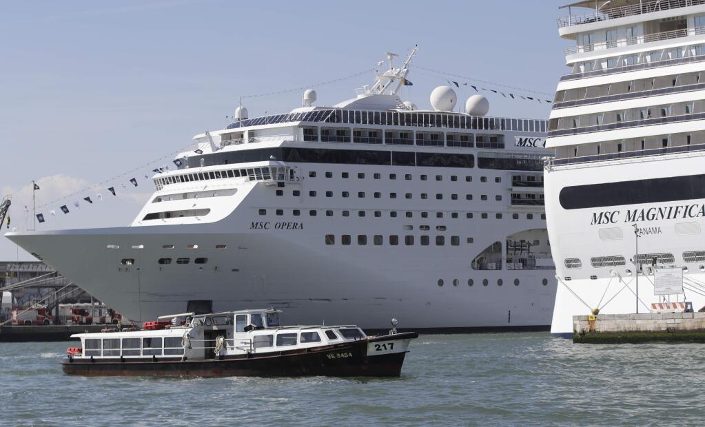 The MSC Opera cruise ship, left, is moored in Venice, Italy, Sunday, June 2, 2019. A towering, out-of-control cruise ship rammed into a dock and a tourist river boat on a busy Venice canal. Italian media reported that at least five people were injured. (AP Photo/Luca Bruno)