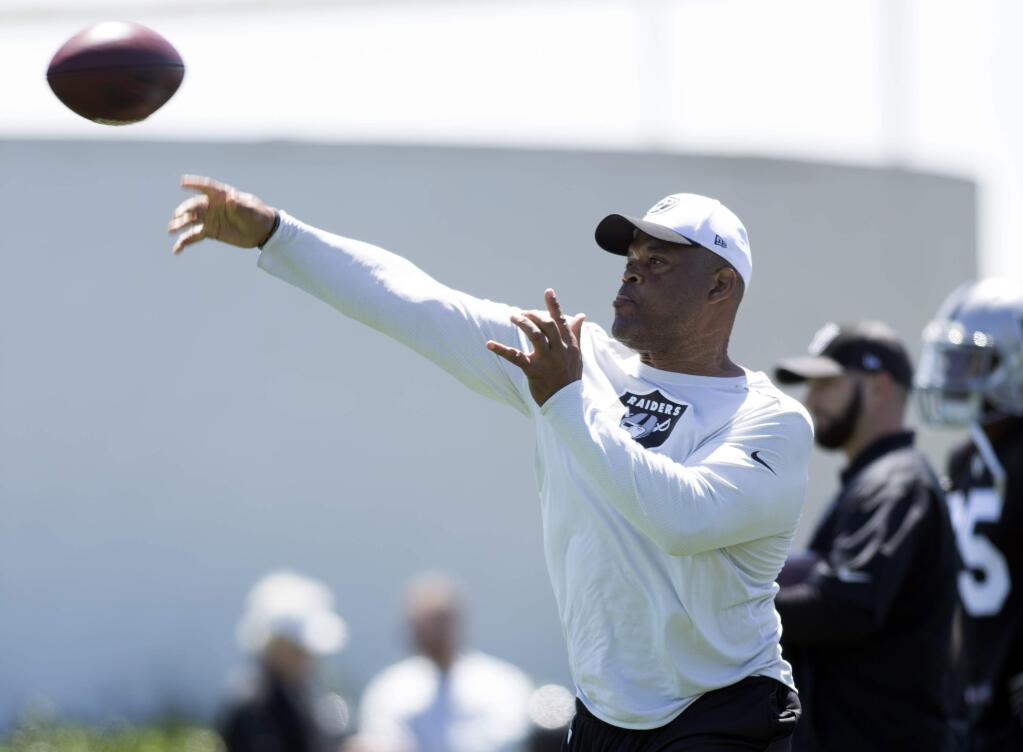 Oakland Raiders defensive coordinator Ken Norton Jr. throws the ball during a passing drill at a rookie minicamp, Friday, May 5, 2017, at the eam's headquarters in Alameda. (AP Photo/D. Ross Cameron)