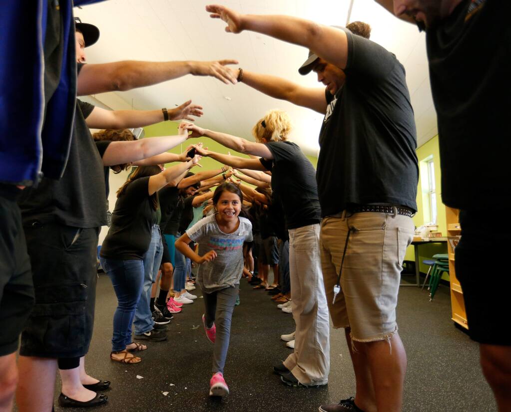 Sofia Renteria, 9, runs through a welcoming tunnel made by members of Transcendence Theatre Company during their service mentorship at the Boys and Girls Club of Sonoma Valley in Sonoma, California, on Wednesday, August 30, 2017. (Alvin Jornada / The Press Democrat)