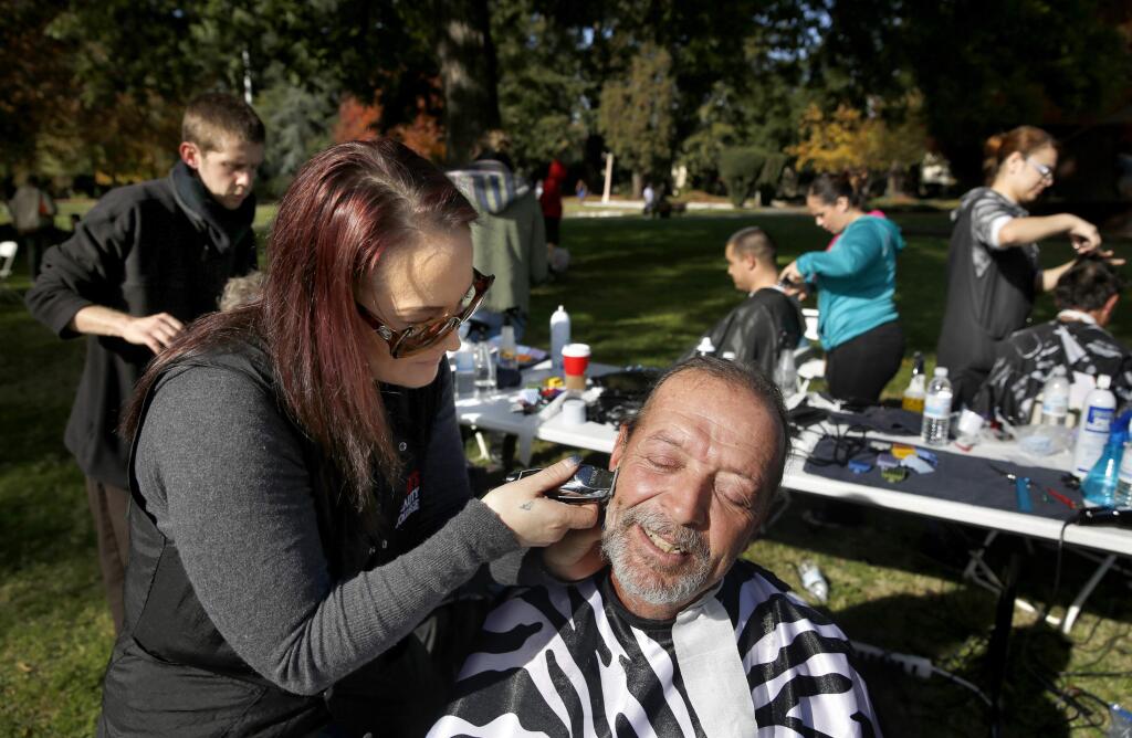Christy Ney trims Steve Masterson's beard during a 'Haircuts for the Homeless' event at Juilliard Park on Sunday, Nov. 22, 2015 in Santa Rosa. (BETH SCHLANKER / The Press Democrat)