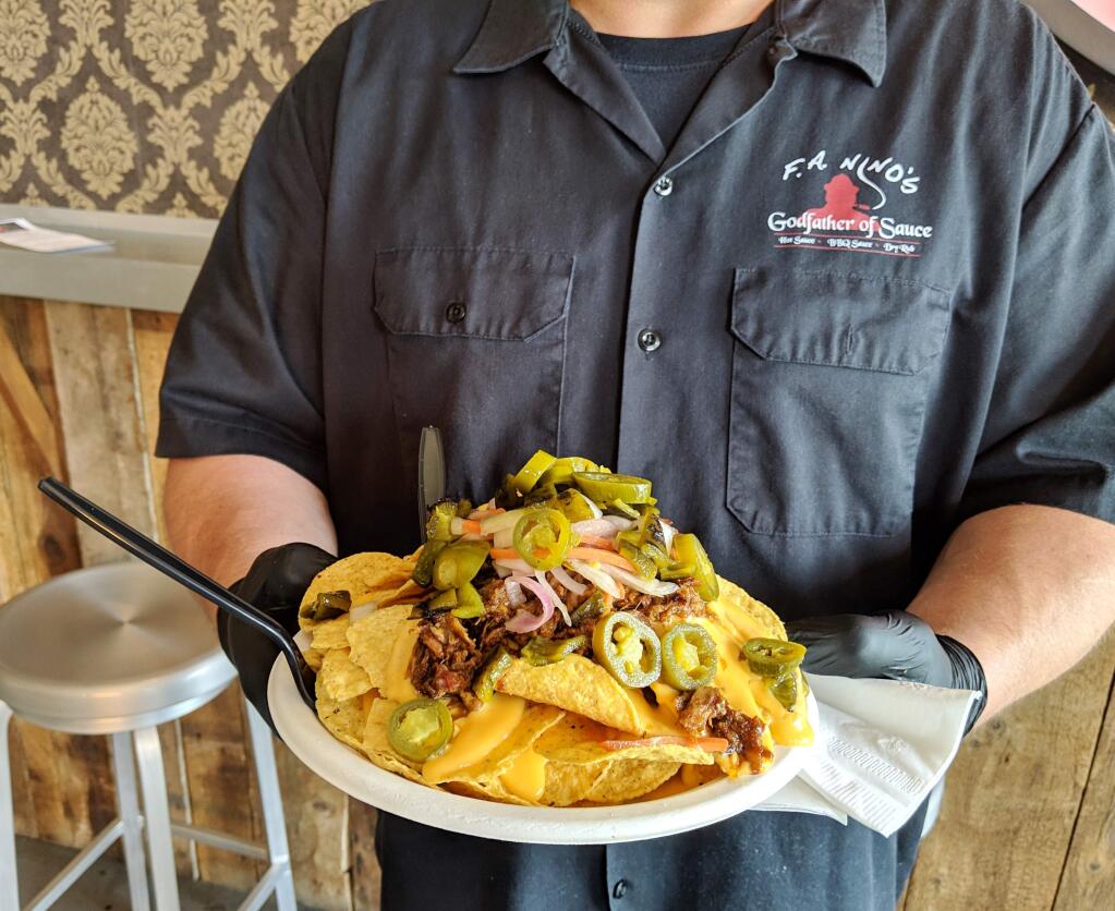 F.A. Ninos' Shawn Kaffun offers up a plate of nachos. (HOUSTON PORTER/FOR THE ARGUS-COURIER)
