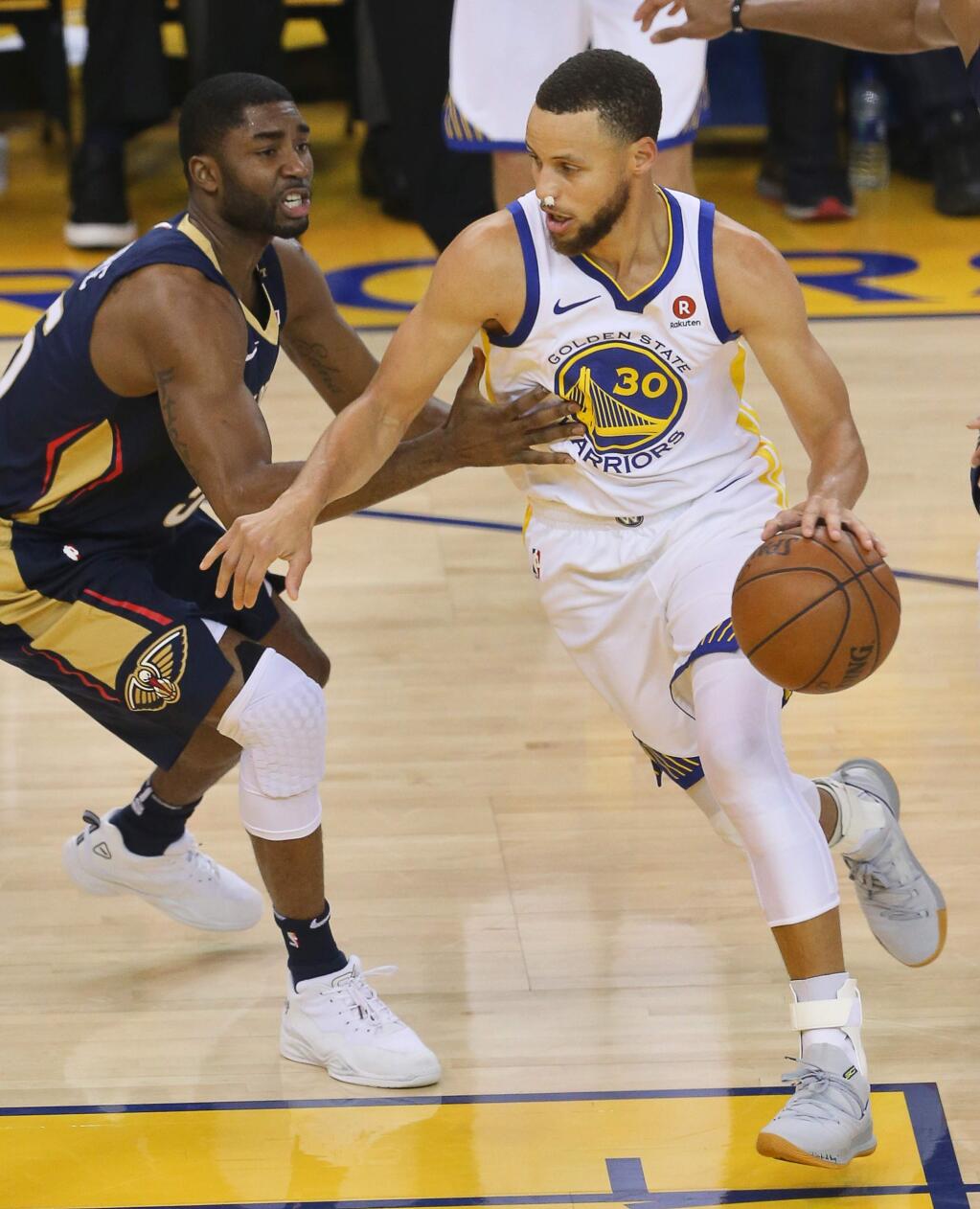 Golden State Warriors guard Stephen Curry drives around New Orleans Pelicans forward E'Twaun Moore, during their game in Oakland on Tuesday, May 8, 2018. (Christopher Chung/ The Press Democrat)