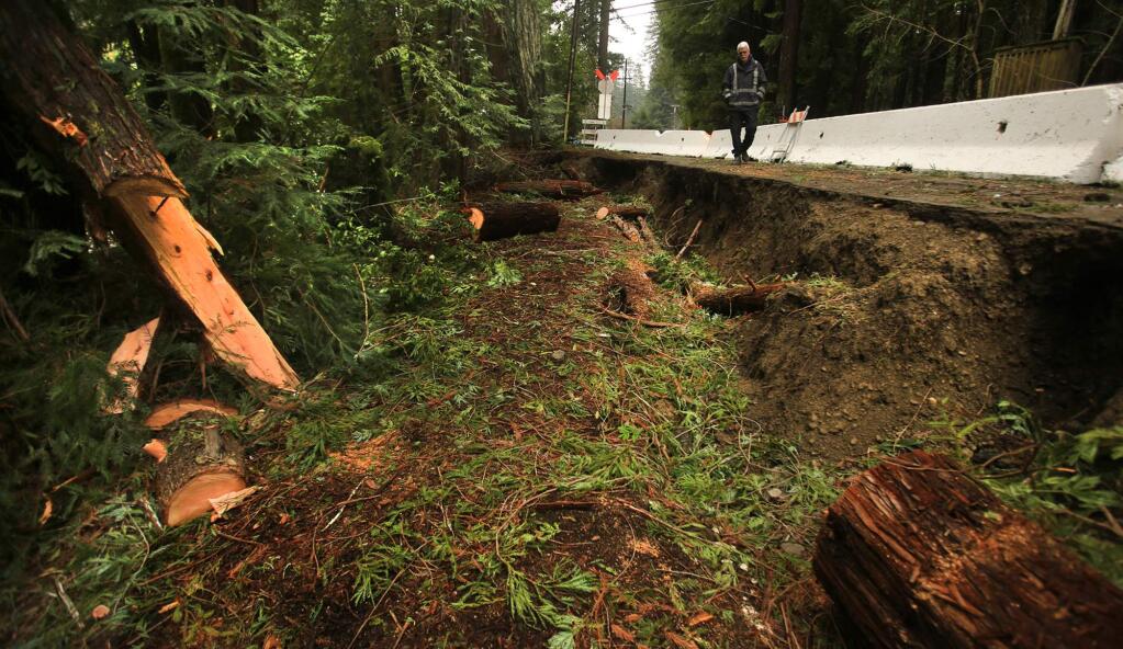 Monte Rio Fire Chief Steve Baxman walks a section of Cazadero Highway, equal distance between Highway 116 and the town of Cazadero, that has given way, a victim of heavy winter rains, Tuesday Jan. 17, 2017. (Kent Porter / Press Democrat) 2017