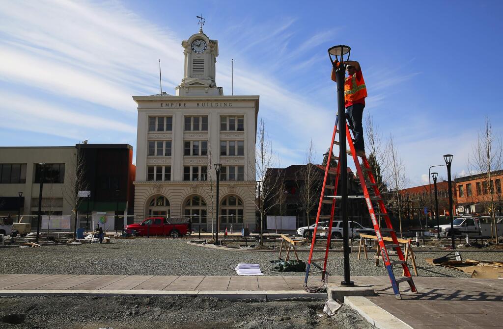Jeremy Aragon of Mike Brown Electric adusts a photocell on a new streetlight in Old Courthouse Square. A dedication ceremony for the reunified square is set for April 29. (CHRISTOPHER CHUNG / The Press Democrat)