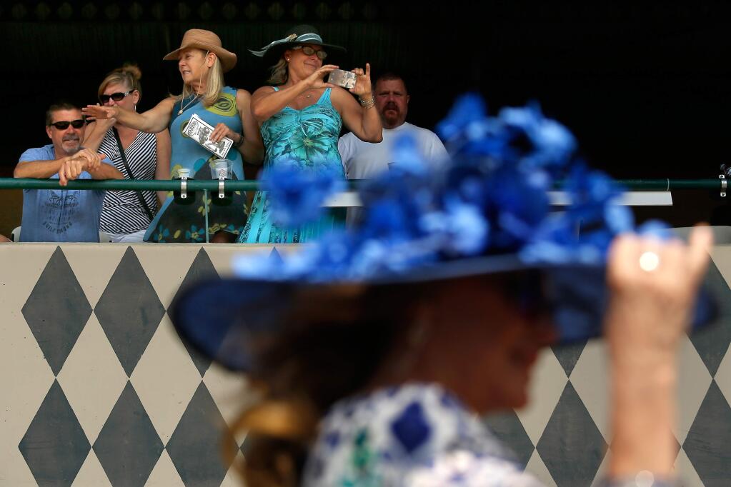 From their box seats, Suzanne Young, upper right, Jo Lalicker and Terri Froman watch a parade of colorful hats pass by during Hat Day at Wine Country Racing at the Sonoma County Fair in Santa Rosa, California, on Saturday, August 11, 2018. (Alvin Jornada / The Press Democrat)