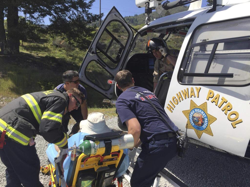 In this Sunday, April 22, 2018 photo released by the California Highway Patrol Golden Gate Division Air Operations, Marin County Fire Department emergency responders assist a hiker with multiple rattlesnake bites on Mount Tamalpais State Park, Calif., into a landed CHP H-30 helicopter to airlift the hiker to John Muir Medical Center in Walnut Creek, Calif. The patient is in stable condition. Officials are warning residents in the eastern region of the San Francisco By Area about rattlesnakes following two recent bites. The park district's advisory warns residents that the snakes like to explore when the weather gets warm. They say hikers should never go alone, always pay close attention to the ground and keep themselves and their pets on designated trails. (CHP Golden Gate Division Air Operations via AP)