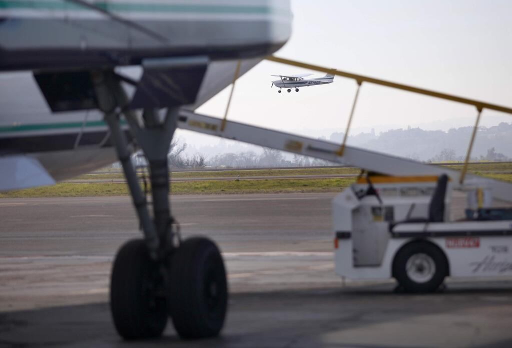 A plane lands as a Horizon Air flight prepares to leave the gate at the Sonoma County Airport on Thursday, January 22, 2015 in Santa Rosa, California . (BETH SCHLANKER/ The Press Democrat)