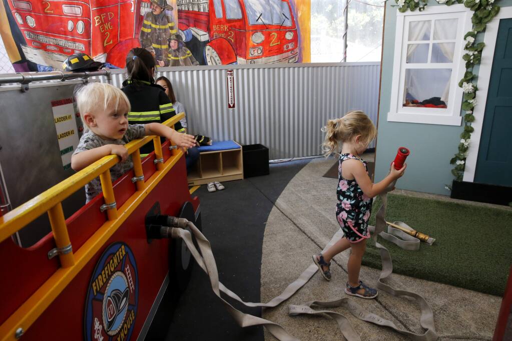 Gregory Webb, 2, left, and his sister Sophia, right, 4, who lost their Coffey Park home in the Tubbs Fire, play in the new Firefighter Playhouse Exhibit at the Children's Museum of Sonoma County in Santa Rosa on Tuesday, June 26, 2018. (Beth Schlanker/ The Press Democrat)