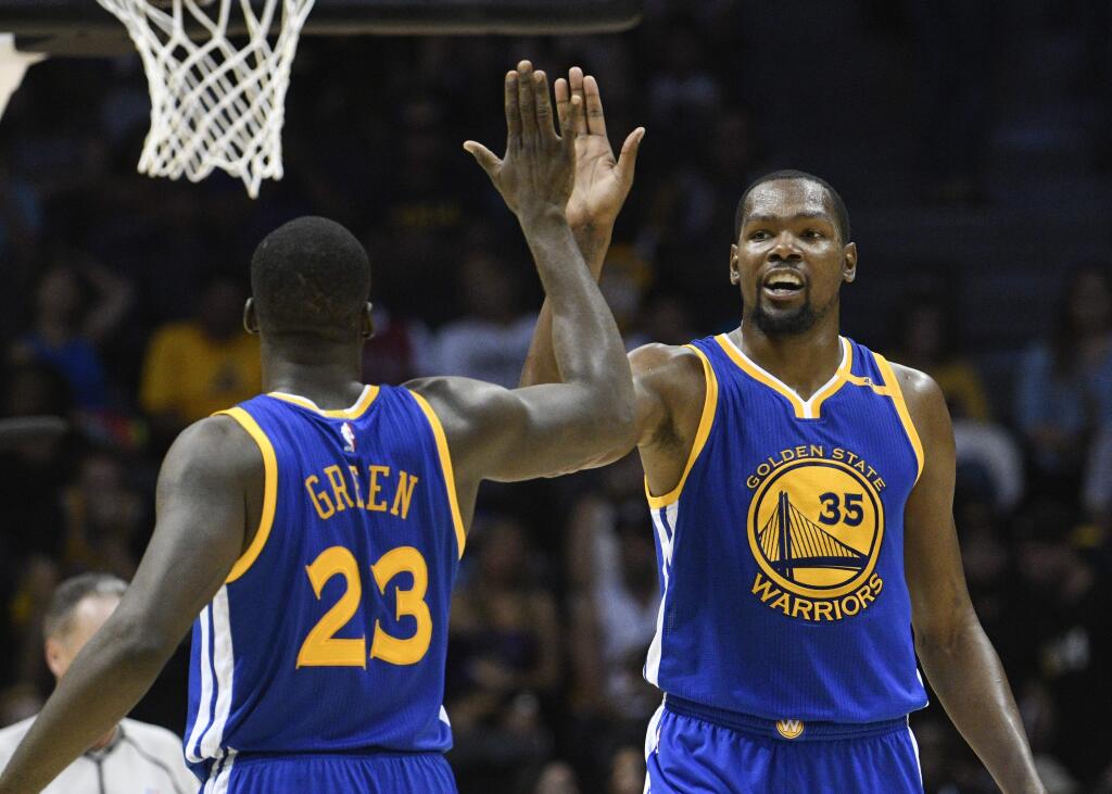 Golden State Warriors forward Kevin Durant (35) high-fives Draymond Green (23) after scoring during the second half of a preseason game against the Los Angeles Lakers on Wednesday, Oct. 19, 2016, in San Diego. (AP Photo/Denis Poroy)