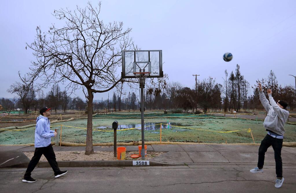 Travis Broadhead, left, and Cordell Meiburg 19 play hoops in front of the razed home of the Broached family, jJanuary 18, 2018 in Coffey Park. (Kent Porter / The Press Democrat) 2018