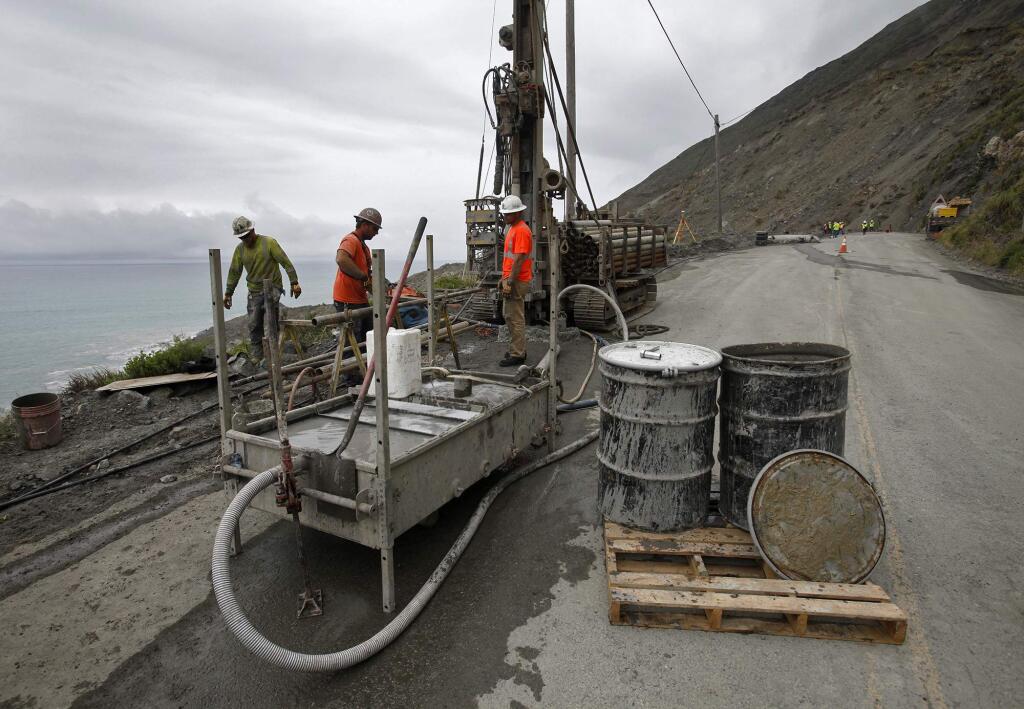 FILE - In this May 25, 2017 file photo, a drilling crew takes soil samples on the southern end of the Mud Creek slide as it covers Highway 1, in southern Monterey County on the coast in Big Sur, Calif. California transportation officials are targeting mid-September for reopening a stretch of iconic Highway 1 in the Big Sur region that was blocked almost a year ago by a massive landslide following winter storms. (Vern Fisher/The Monterey County Herald via AP,File)