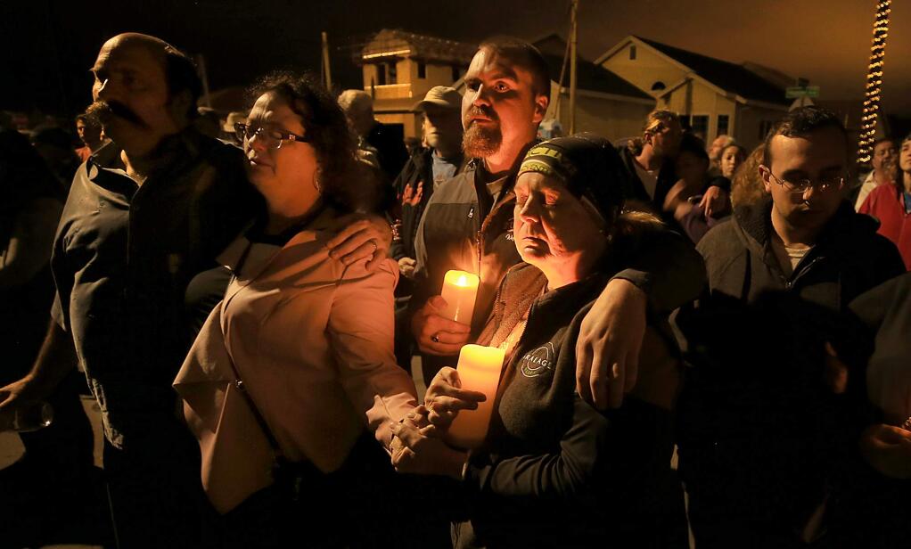 From left, Eric and Melany Callagher from Astaire Court and Nathan and Laurel Quast of Monticello Court, who lost their homes to the Tubbs fire last October share in a moment of silence during a remembrance of the fire marking the one year anniversary, Tuesday Oct. 9, 2018. Both couples are rebuilding. (Kent Porter / The Press Democrat) 2018