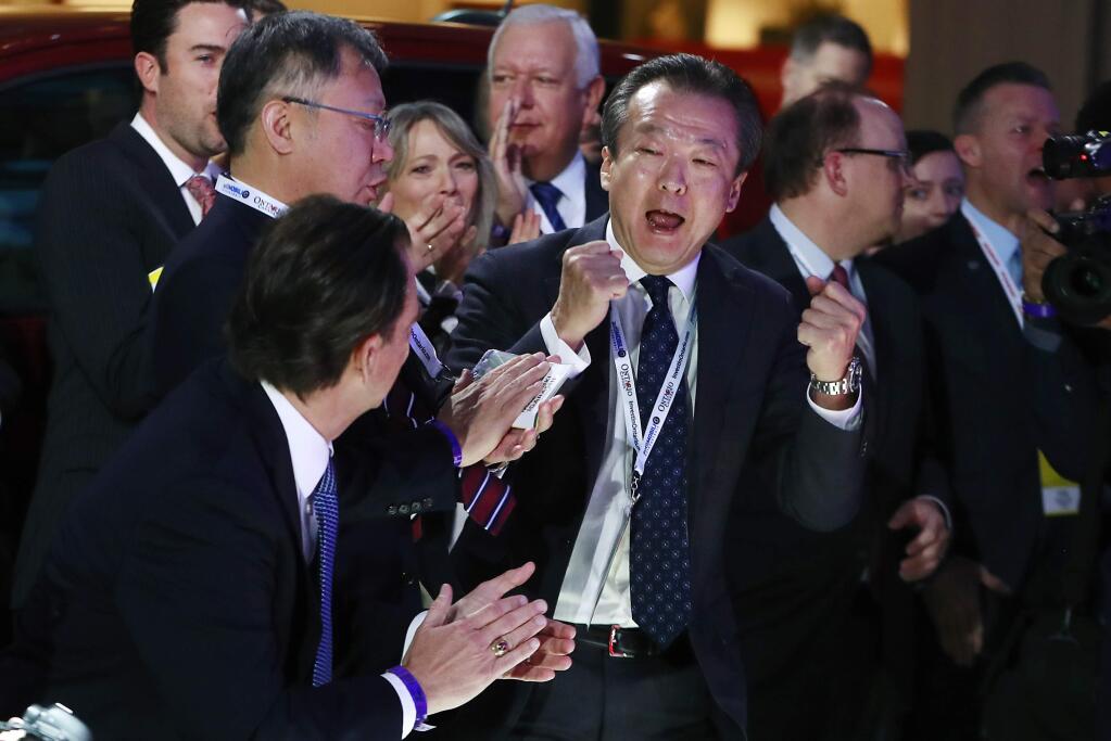 Toshiaki Mikoshiba, center, president and CEO of American Honda Motor Co., reacts after the 2018 Honda Accord won car of the year during the North American International Auto Show, Monday, Jan. 15, 2018, in Detroit. (AP Photo/Carlos Osorio)