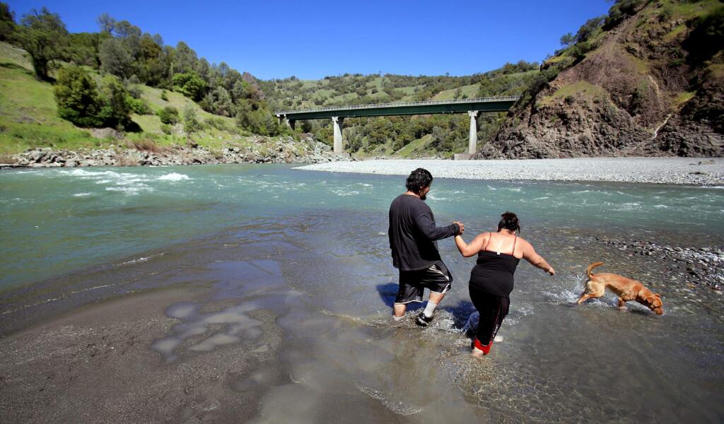 A day of hot weather was enough for Joseph and Rosie Hoaglen of Covelo with their dog dozer to cool off in the middle fork of the Eel River in Dos Rios, Wednesday March 7, 2016. (Kent Porter / Press Democrat) 2016