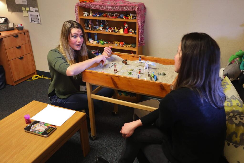 Associate marriage and family therapist Laura Guyn, left, and clinical supervisor Casandra McGee discuss a child client's unprompted exercise in sand tray intervention at the Child Parent Institute, in Santa Rosa on Friday, March 16, 2018. (Christopher Chung/ The Press Democrat)