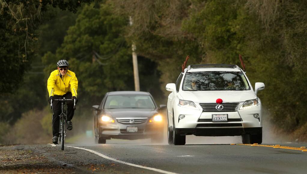 Andy Elkind of Healdsburg rides Dry Creek Rd. on a rainy Christmas eve. Starting January 1st, a new law requires cyclists to pull over when five or more cars are backed up behind them. (JOHN BURGESS / The Press Democrat)