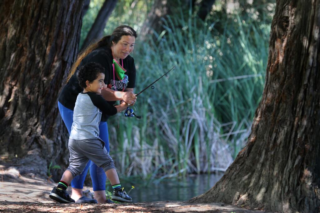 Melinda Hildebrand helps her son, Ronald, 3, cast a fishing line into the water on Mother's Day at Roberts Lake Park in Rohnert Park, California on Sunday, May 10, 2020. (BETH SCHLANKER/ The Press Democrat)