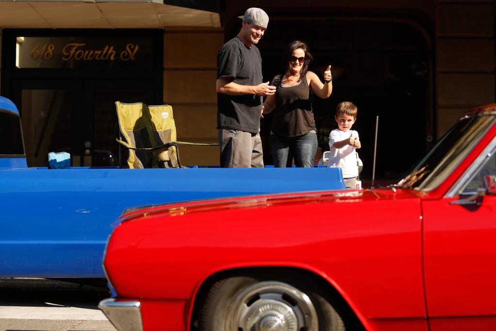 Zach Holbrook, 3, and his parents Clover and Dustin show their approval for some of the classic cars passing by during the 14th annual Peggy Sue's Car Show and Cruise in Santa Rosa, California on Saturday, June 11, 2016. (Alvin Jornada / The Press Democrat)