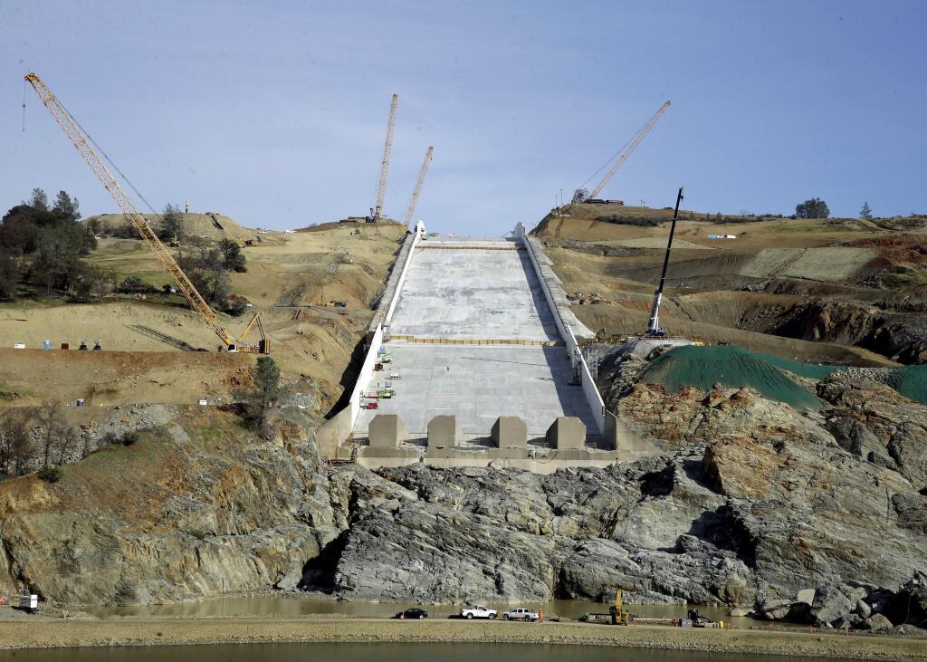 FILE - In this Nov. 30, 2017, file photo, work continues on the Oroville Dam spillway in Oroville, Calif. National dam safety experts say long-term and systemic failures by officials in California and elsewhere caused last year's near-disaster at the nation's tallest dam. The report released Friday, Jan. 5, 2018, comes from experts appointed to investigate the causes of spillway collapses at California's Oroville Dam. (AP Photo/Rich Pedroncelli, File)