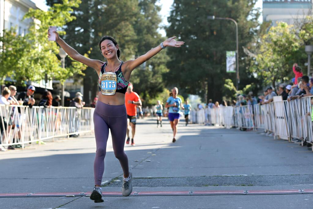 Claudia Lavina crosses the finish line of the Santa Rosa Half-Marathon on Fourth St. in Santa Rosa on Sunday, August 25, 2019. (BETH SCHLANKER/ The Press Democrat)