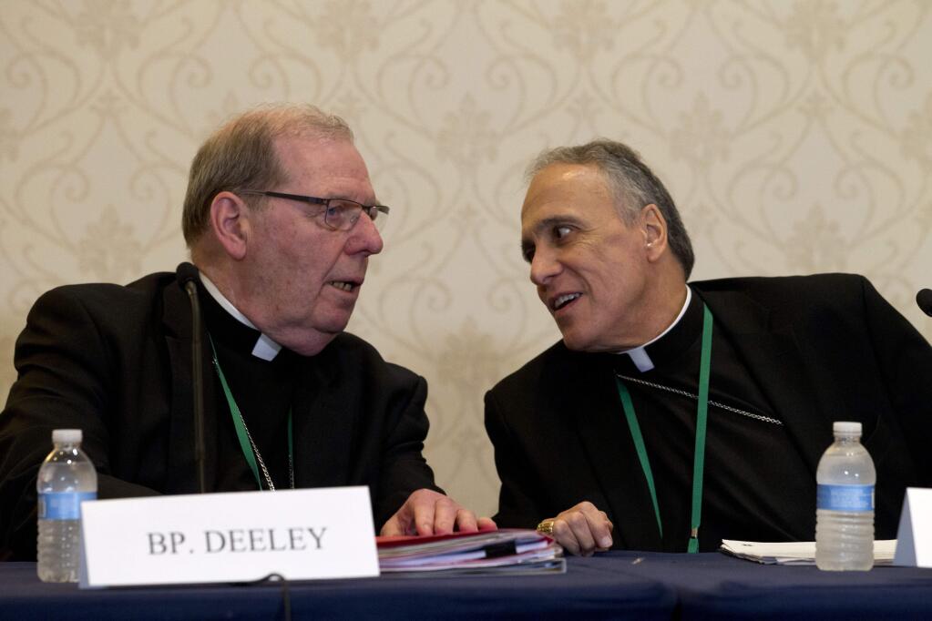 Bishop Robert Deeley of Portland Bishop of Diocese of Portland, left, speaks with Cardinal Daniel DiNardo of the Archdiocese of Galveston-Houston, during a news conference at the United States Conference of Catholic Bishops (USCCB), 2019 Spring meetings in Baltimore on Tuesday, June 11, 2019. (AP Photo/Jose Luis Magana)