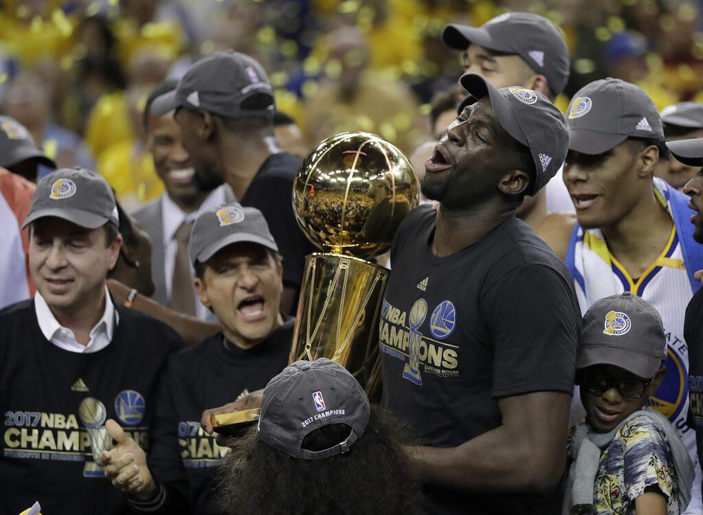 Golden State Warriors forward Draymond Green (23) holds the Larry O'Brien NBA Championship Trophy after Game 5 of basketball's NBA Finals against the Cleveland Cavaliers in Oakland, Calif., Monday, June 12, 2017. The Warriors won 129-120 to win the NBA championship. (AP Photo/Marcio Jose Sanchez)