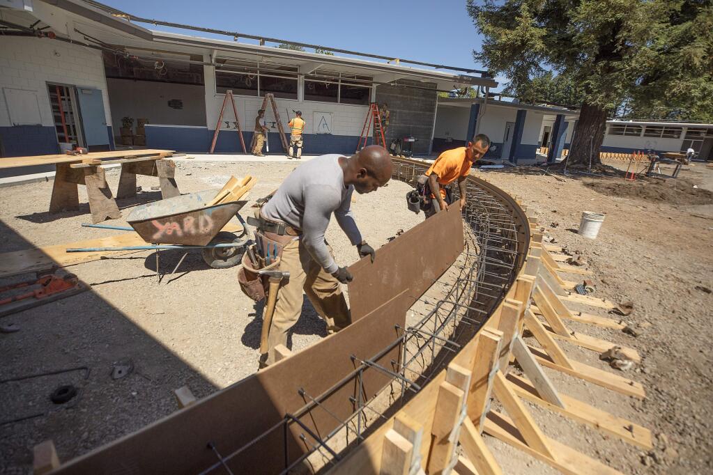Antwon Webb, left, and Jordan Atalig frame in a seat wall as part of the remodel of the new Technology High School in Rohnert Park. The school moves from the Sonoma State campus to the former Waldo Elementary campus. (photo by John Burgess/The Press Democrat)
