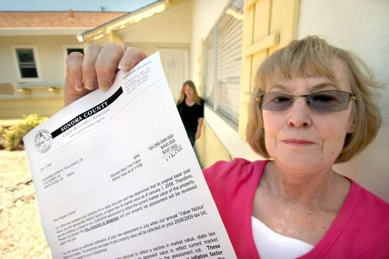 Joan Edwards holds the letter from the Sonoma county Assessor's office letting her know that her Santa Rosa property that she bought two years ago as an investment and housing for her daughter Cheryl Edwards, seen in background, has been reduced by 25% and thus she will see a reduction in her property tax. (Scott Manchester / The Press Democrat)