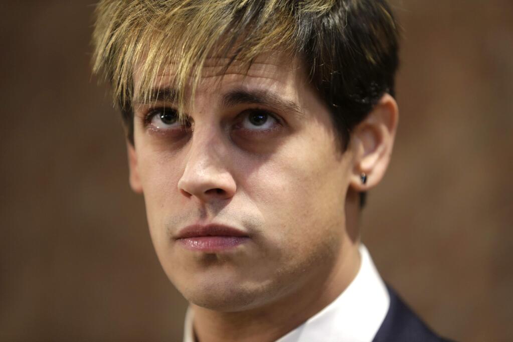 Milo Yiannopoulos listens during a news conference in New York, Tuesday, Feb. 21, 2017. Yiannopoulos has resigned as editor of Breitbart Tech after coming under fire from other conservatives over comments on sexual relationships between boys and older men. (AP Photo/Seth Wenig)