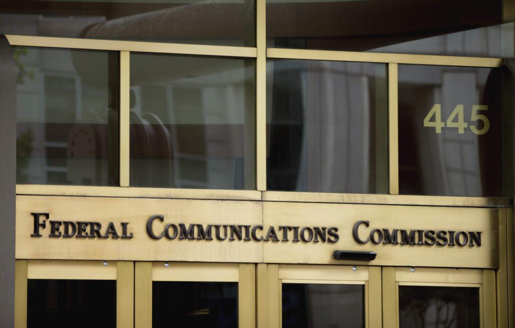FILE - This June 19, 2015, file photo, shows the entrance to the Federal Communications Commission (FCC) building in Washington. 'Net neutrality' regulations, designed to prevent internet service providers like Verizon, AT&T, Comcast and Charter from favoring some sites and apps over others, are on the chopping block. Federal Communications Commission Chairman Ajit Pai, a Republican, on Tuesday, Dec. 12, 2017, unveiled a plan to undo the Obama-era rules that have been in place since 2015. (AP Photo/Andrew Harnik, File)