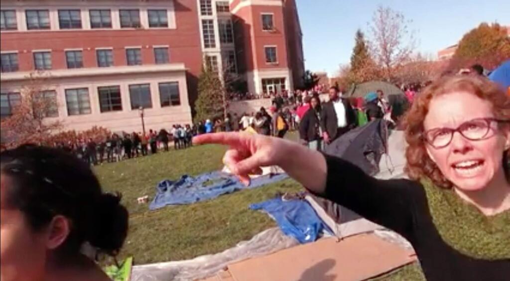In this Nov. 9, 2015 frame from video provided by Mark Schierbecker, Melissa Click, right, an assistant professor in Missouri's communications department, confronts Schierbecker and later calls for 'muscle' to help remove him from the protest area in Columbia, Mo. Protesters credited with helping oust the University of Missouri System's president and the head of its flagship campus welcomed reporters to cover their demonstrations Tuesday, a day after a videotaped clash between some protesters and a student photographer drew media condemnation as an affront to the free press. (Mark Schierbecker via AP) MANDATORY CREDIT