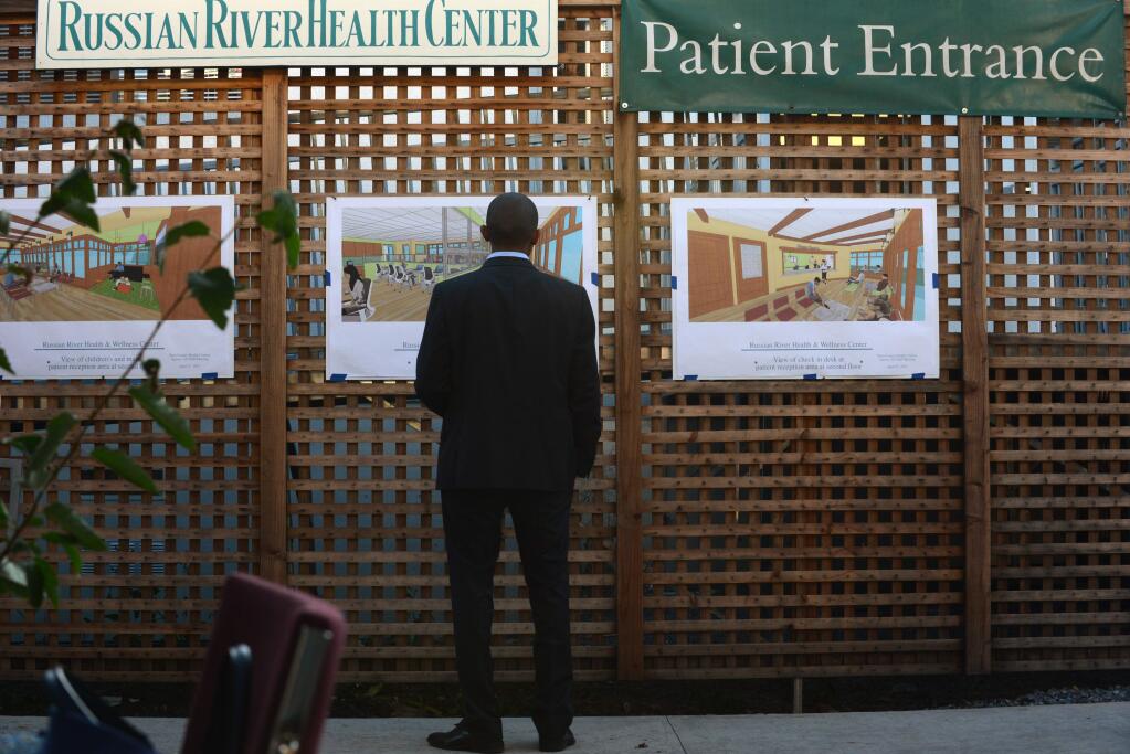 Dawit Tesfasilassie looks over images on display showing plans for the new Russian River Health & Wellness Center at the capital campaign launch party in Guerneville, California, on Friday, Aug. 18, 2017, to rebuild the new Russian River Health & Wellness Center. (Erik Castro / for The Press Democrat)