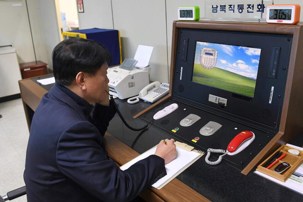 A South Korean government official communicates with a North Korean officer during a phone call on the dedicated communications hotline at the border village of Panmunjom in Paju, South Korea, Wednesday, Jan. 3, 2018. North Korean leader Kim Jong Un reopened a key cross-border communication channel with South Korea on Wednesday, another sign easing animosity between the rivals even as Kim traded combative threats of nuclear war with President Donald Trump. (Yonhap via AP)